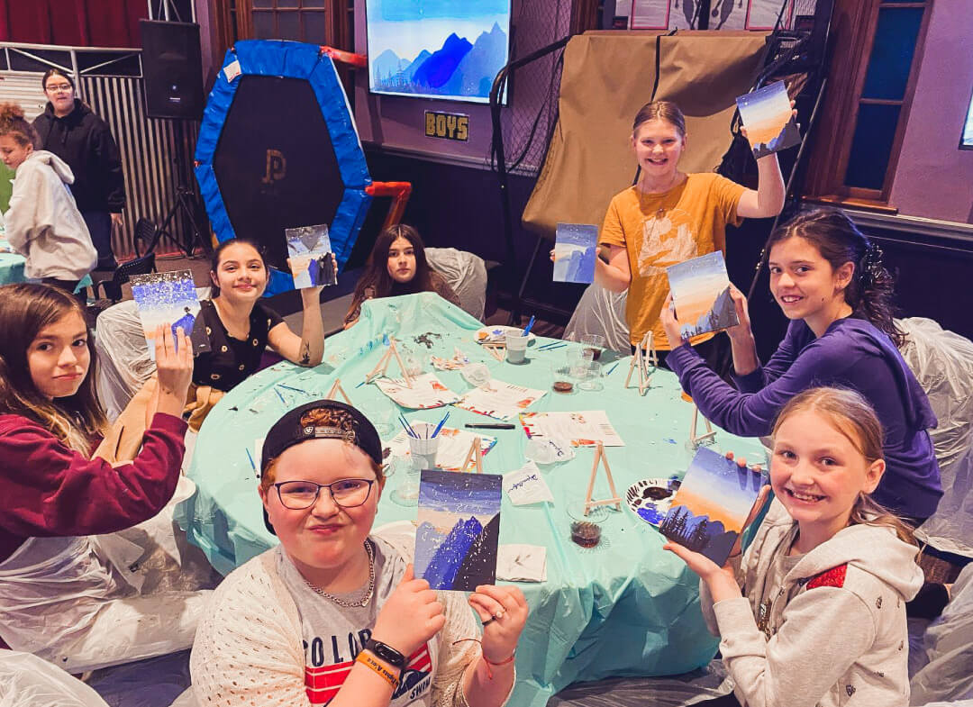 middle-school-girls-showing-paintings