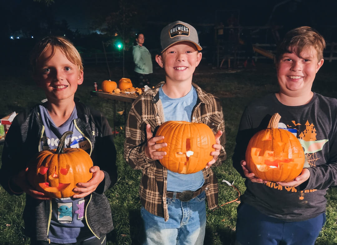 three-boys-holding-carved-pumpkins